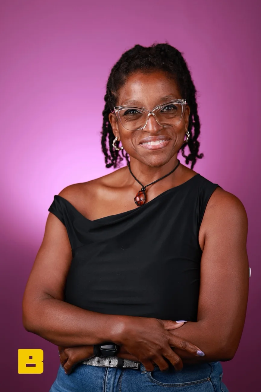 Dr Kareem smiling in a portrait against a purple background